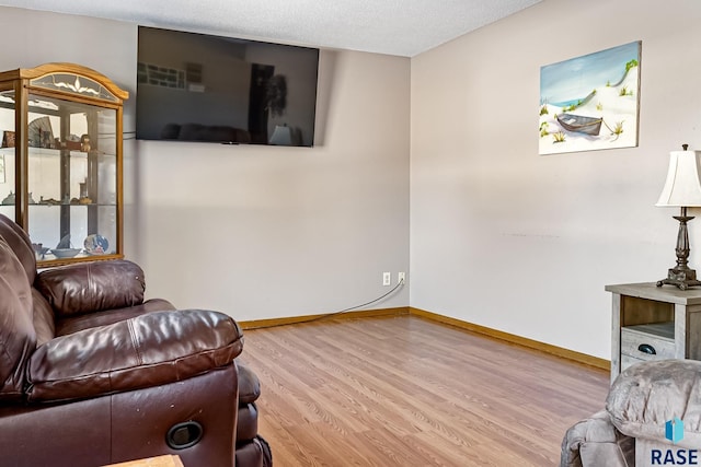 sitting room featuring light hardwood / wood-style floors and a textured ceiling