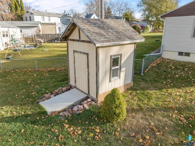 view of outbuilding featuring a playground and a yard