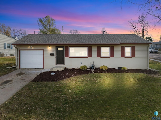 single story home featuring a lawn and a garage