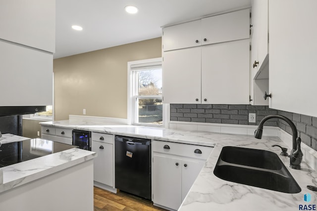 kitchen with beverage cooler, white cabinets, light wood-type flooring, sink, and black dishwasher