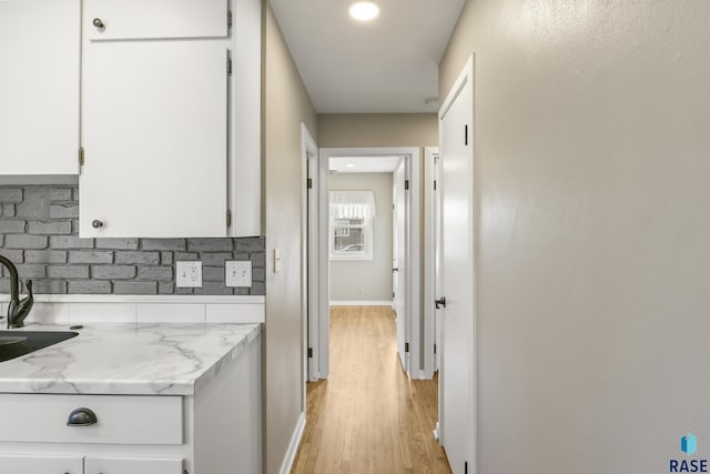 hallway with sink and light wood-type flooring