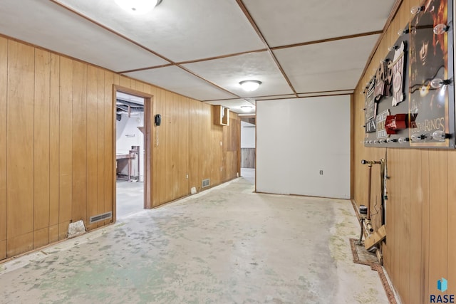 basement featuring wooden walls