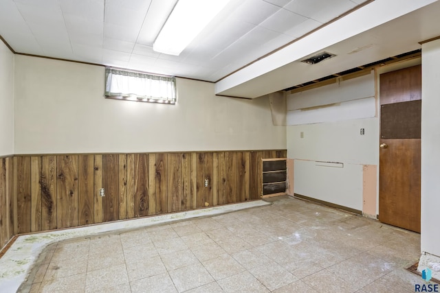 basement featuring wooden walls