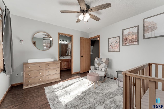 bedroom with ensuite bath, a nursery area, ceiling fan, and dark wood-type flooring