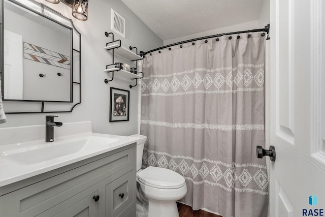 bathroom with toilet, vanity, and a textured ceiling