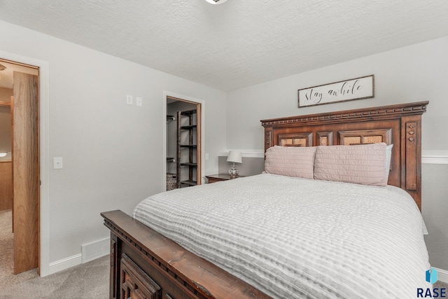 carpeted bedroom featuring a textured ceiling