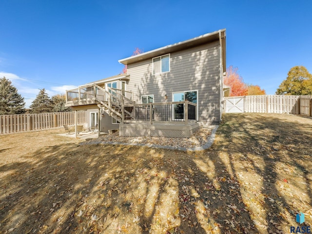 back of property with a yard and a wooden deck