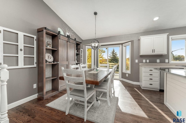 dining area featuring lofted ceiling, dark hardwood / wood-style flooring, an inviting chandelier, and a barn door