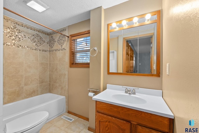 full bathroom featuring toilet, tile patterned floors, vanity, tiled shower / bath, and a textured ceiling