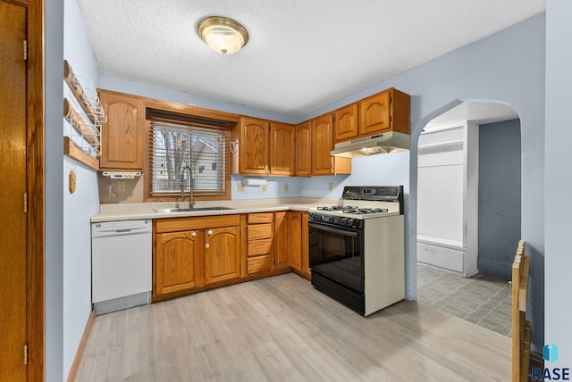 kitchen with sink, a textured ceiling, dishwasher, light hardwood / wood-style flooring, and gas stove