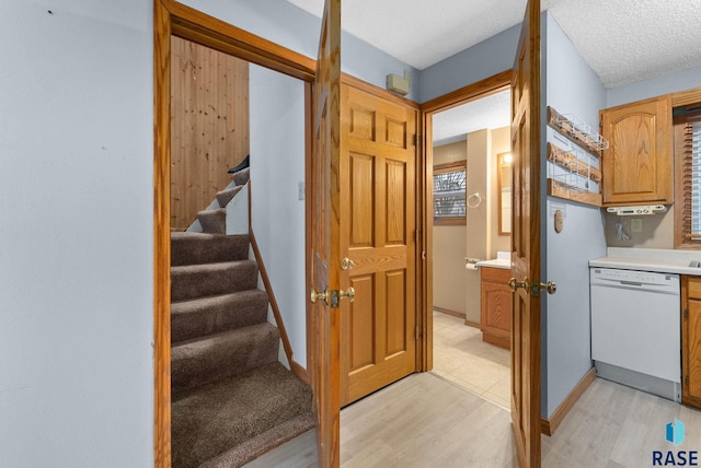 stairs featuring a textured ceiling and hardwood / wood-style floors