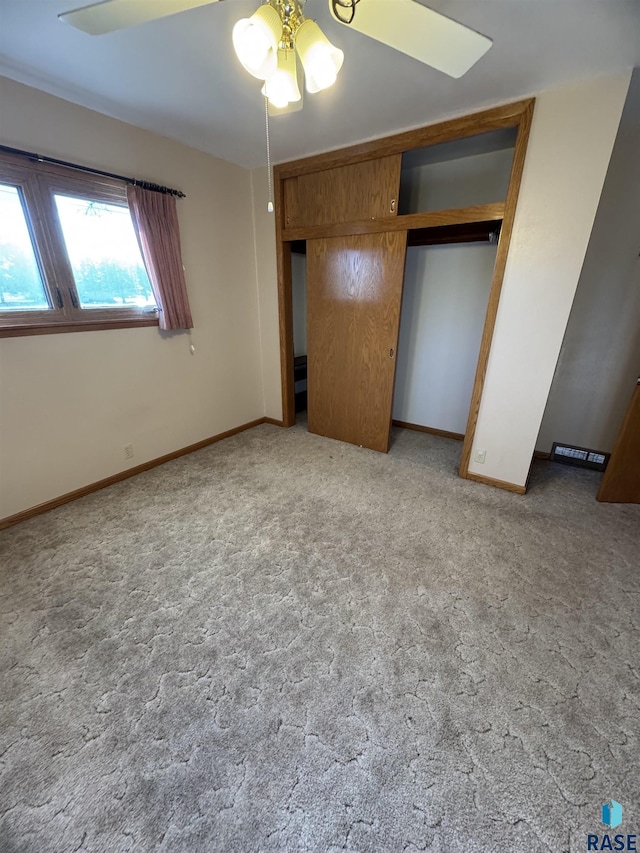 unfurnished bedroom with light carpet, a closet, and ceiling fan