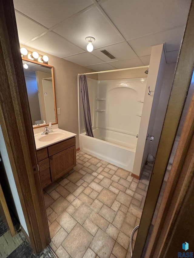 bathroom featuring a paneled ceiling, vanity, and shower / bath combo with shower curtain