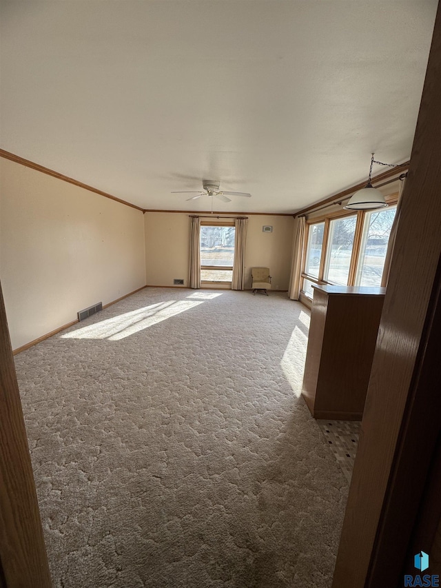 unfurnished room with light carpet, ceiling fan, and crown molding