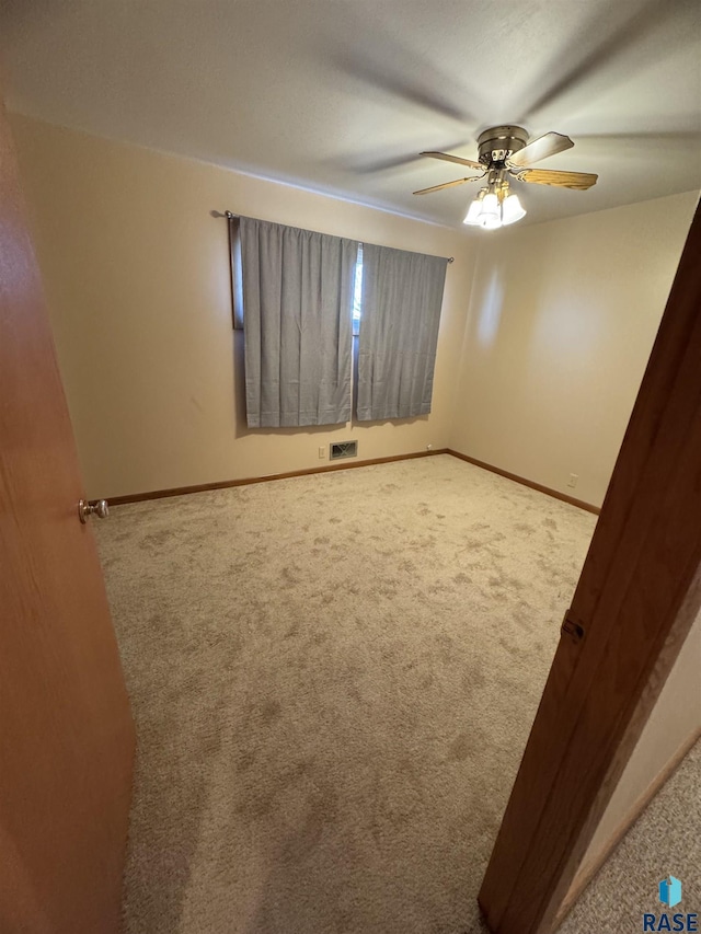 carpeted spare room with ceiling fan