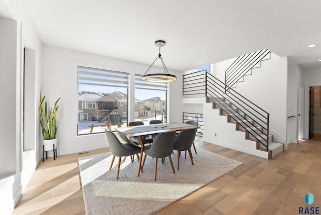 dining area featuring light hardwood / wood-style floors and a chandelier