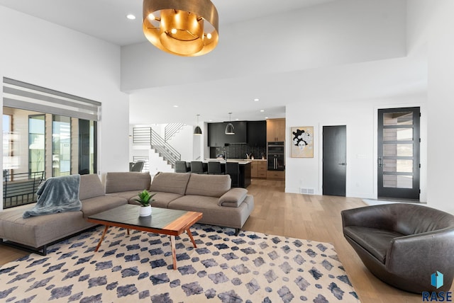 living room with a towering ceiling and light hardwood / wood-style floors