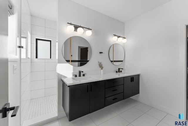 bathroom featuring a tile shower, vanity, and tile patterned floors