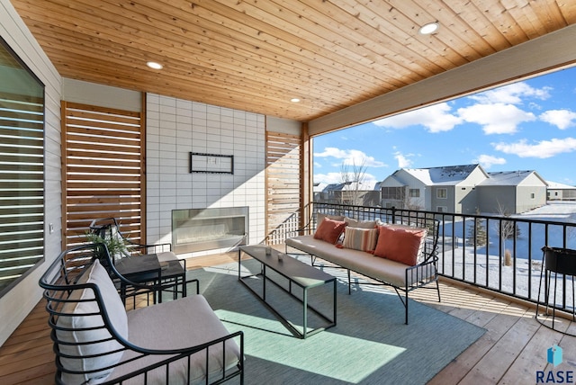 wooden deck with an outdoor living space with a fireplace