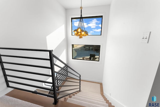 staircase featuring a chandelier