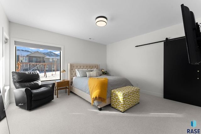 bedroom with a barn door and carpet floors