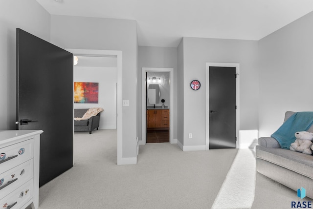 bedroom with light colored carpet and ensuite bathroom