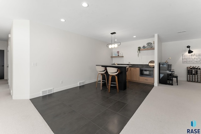 dining area featuring bar area and dark tile patterned floors