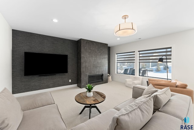 living room with a tile fireplace and carpet flooring