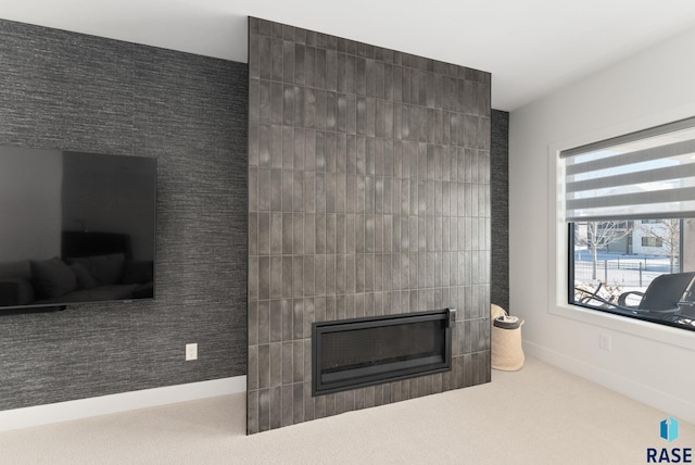 living room with a tiled fireplace and carpet floors