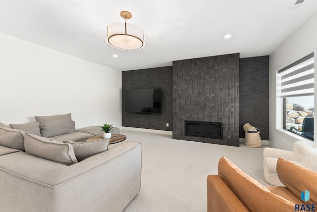 carpeted living room featuring a tile fireplace