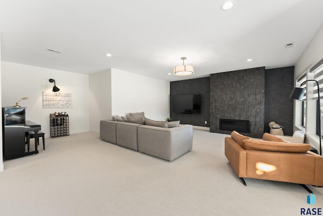 carpeted living room featuring a tile fireplace