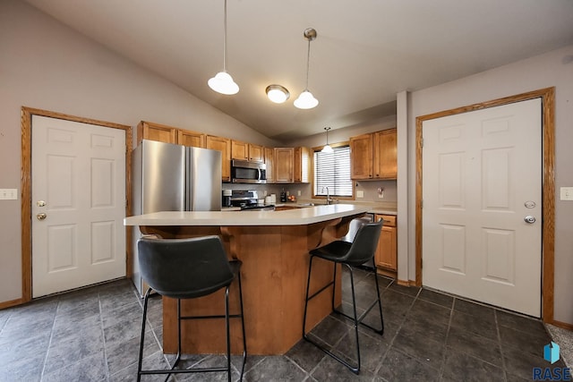 kitchen featuring sink, decorative light fixtures, a center island, a breakfast bar, and appliances with stainless steel finishes