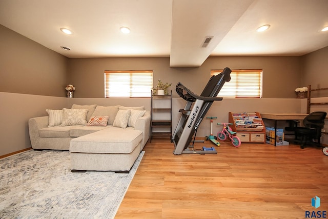 exercise room featuring light wood-type flooring