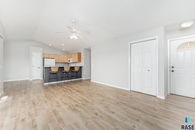 living room featuring vaulted ceiling, light wood-type flooring, and ceiling fan