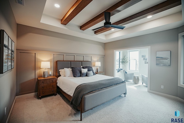 bedroom with ceiling fan, beam ceiling, and light colored carpet