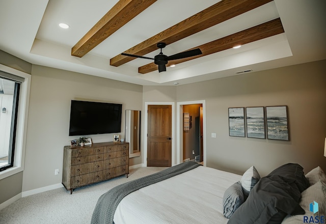 carpeted bedroom featuring ceiling fan and a tray ceiling