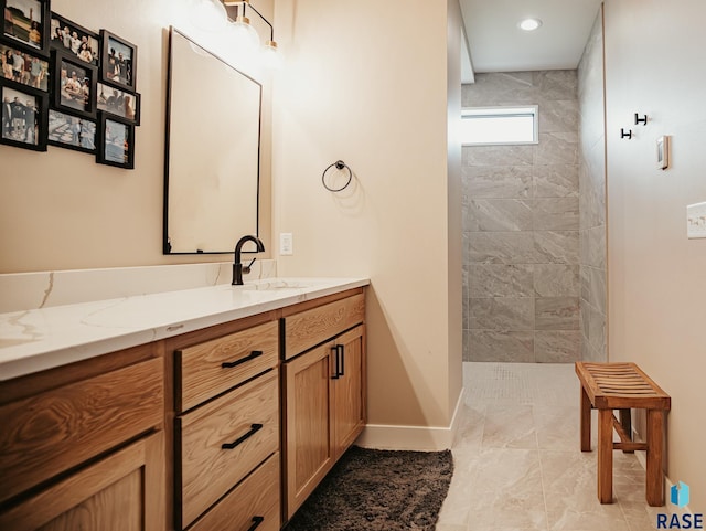 bathroom with vanity, tiled shower, and tile patterned floors