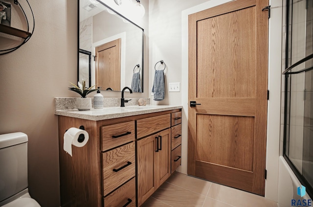 full bathroom with toilet, tile patterned flooring, vanity, and combined bath / shower with glass door