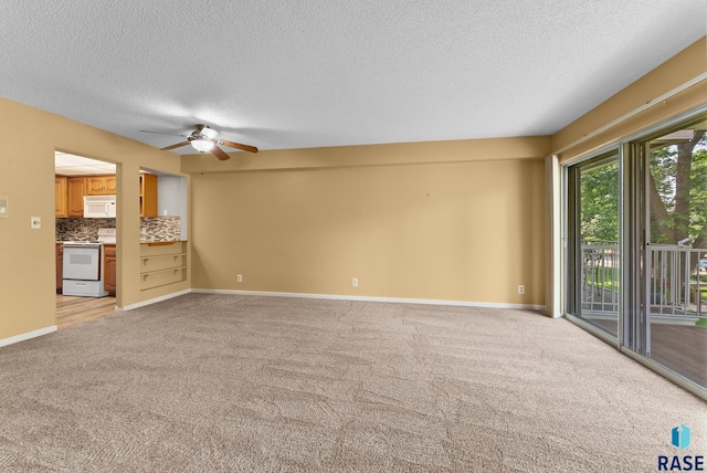 unfurnished living room with a textured ceiling, light carpet, and ceiling fan