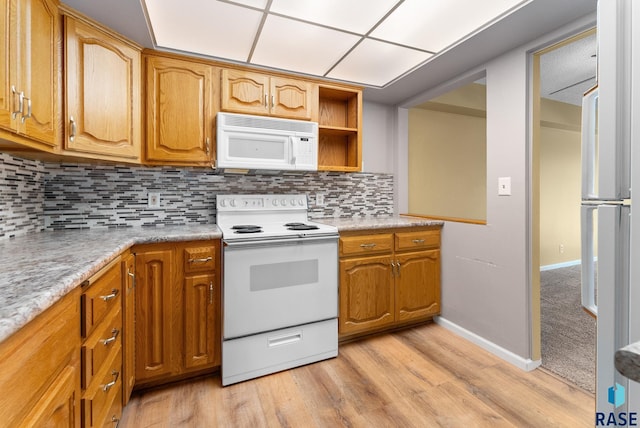 kitchen featuring white appliances, light wood-type flooring, and backsplash