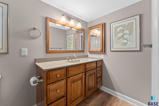 bathroom featuring a textured ceiling, vanity, and hardwood / wood-style flooring