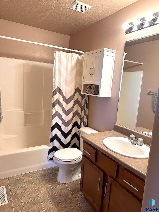 full bathroom with a textured ceiling, vanity, shower / bath combo with shower curtain, and toilet