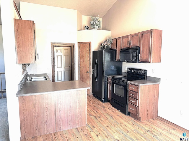 kitchen with black appliances, light hardwood / wood-style flooring, high vaulted ceiling, and sink