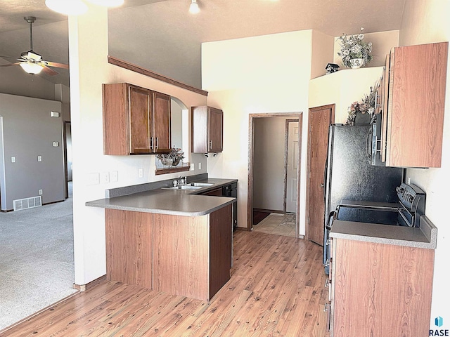 kitchen featuring sink, ceiling fan, kitchen peninsula, electric stove, and light colored carpet