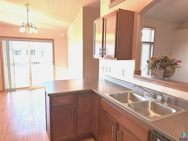 kitchen featuring kitchen peninsula, a textured ceiling, a wealth of natural light, and sink