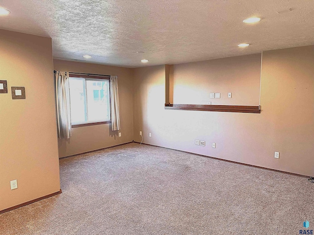 carpeted spare room with a textured ceiling