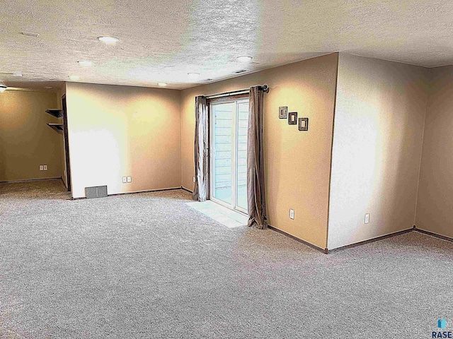 empty room featuring a textured ceiling and carpet