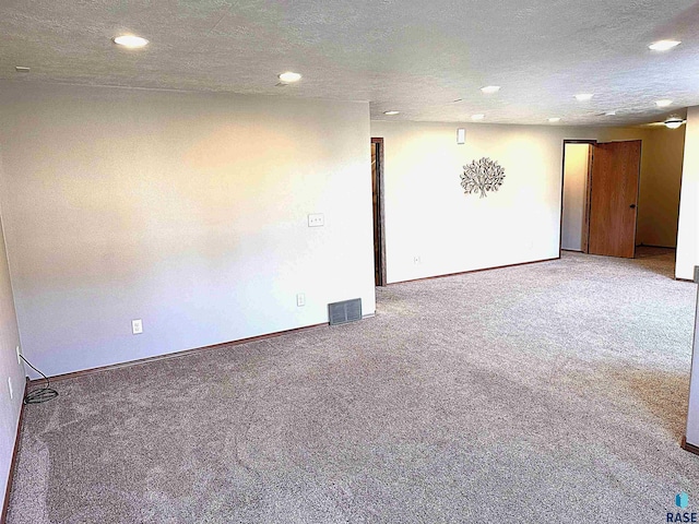 unfurnished room with a textured ceiling and carpet