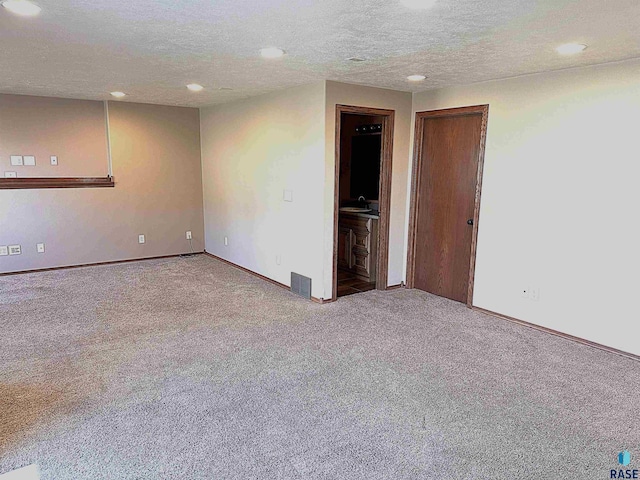 spare room with a textured ceiling and carpet