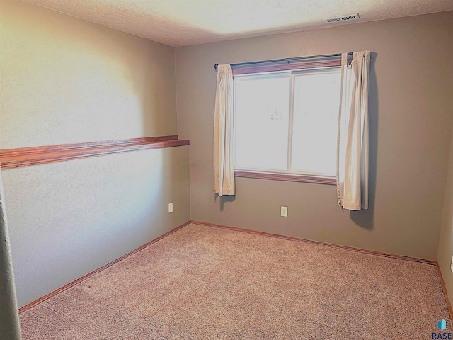 empty room with a textured ceiling and carpet